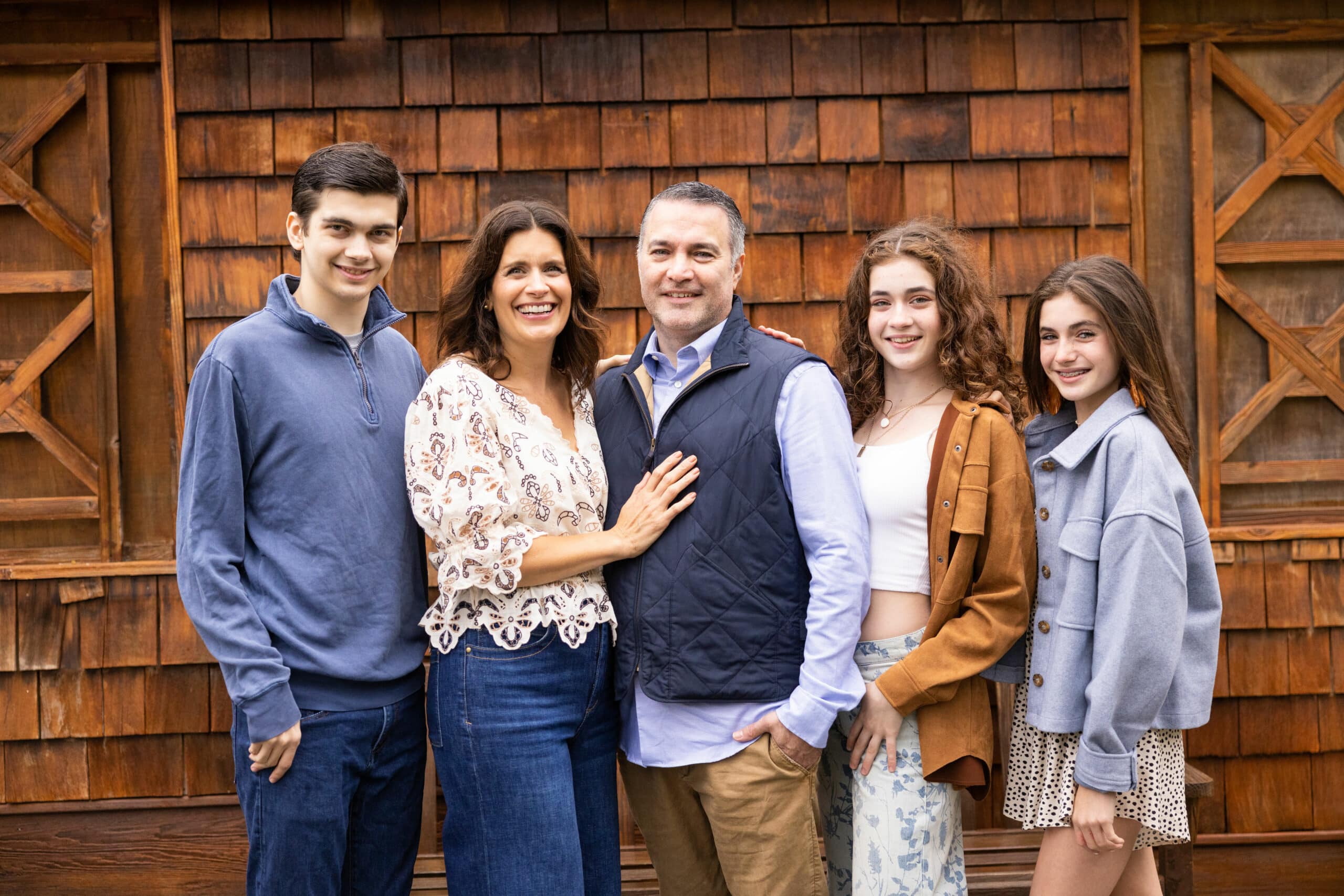 Photo of a family standing in a row and smiling at the camera.
