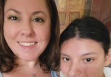 Photo of a woman and her daughter, a tween girl, smiling at the camera. They both have dark hair. The mother is wearing a necklace and a shirt with butterflies on it.