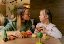 General Disability Resources in Anne Arundel Stock photo of a woman playing with wooden toy blocks with a young girl with Down syndrome.