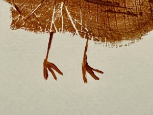 Close-up of two thin turkey feet painted in brown.