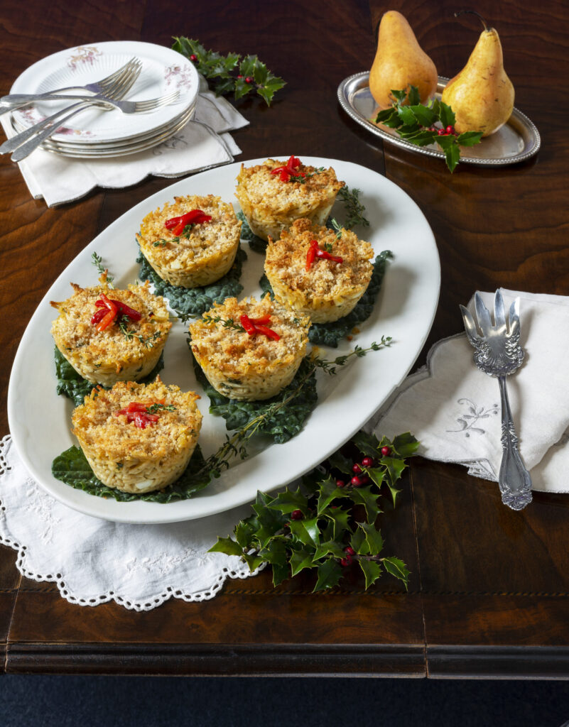 Photo of six muffin-shaped mounds of spaghetti topped with pieces of hard-boiled egg and a dollop of red sauce.
