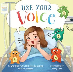 Photo of a book cover with an illustration of a girl with short brown hair lying in a hospital bed and speaking. A speech bubble above her reads "Use Your Voice."