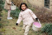 5 Excellent Easter Egg Hunts in Annapolis: April 19-20 Stock photo of a young girl holding an Easter basket and searching for eggs outside.