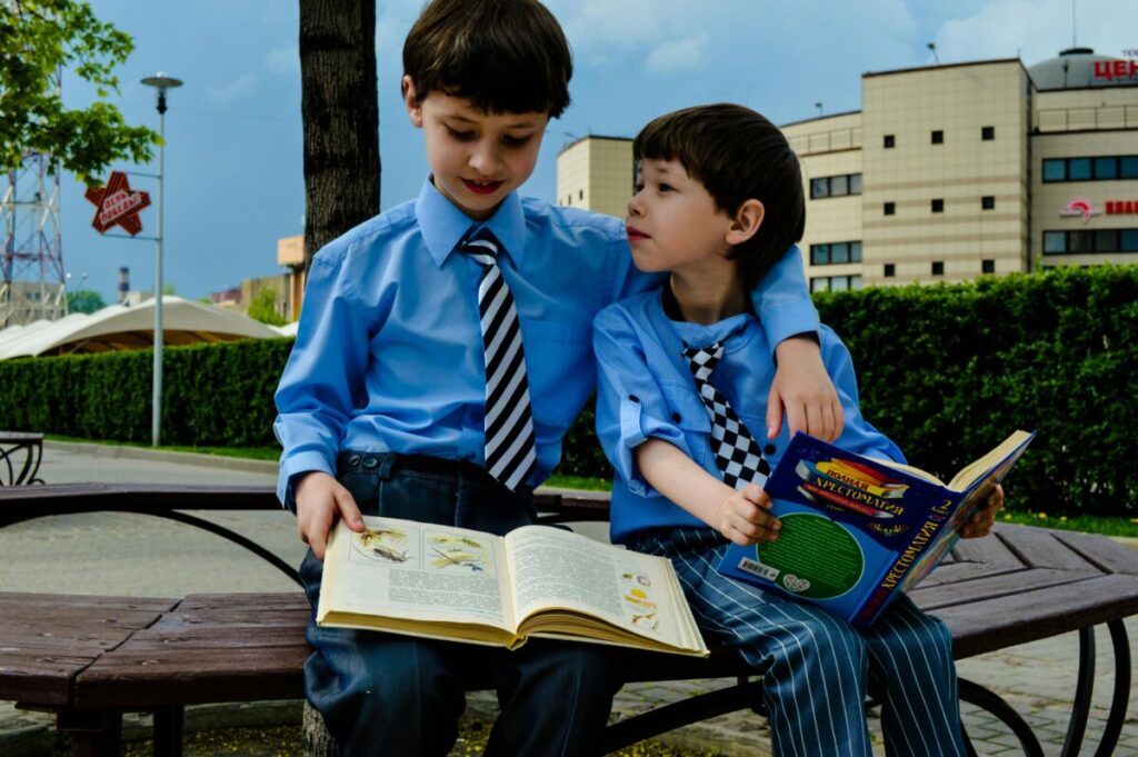 Stock photo of two kids reading books side by side.