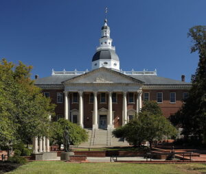 Photo of a state house building with six columns and trees out front.