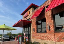 Sheetz storefront in Linthicum Heights, showing a brick building with red roofing and a table with a green umbrella out front