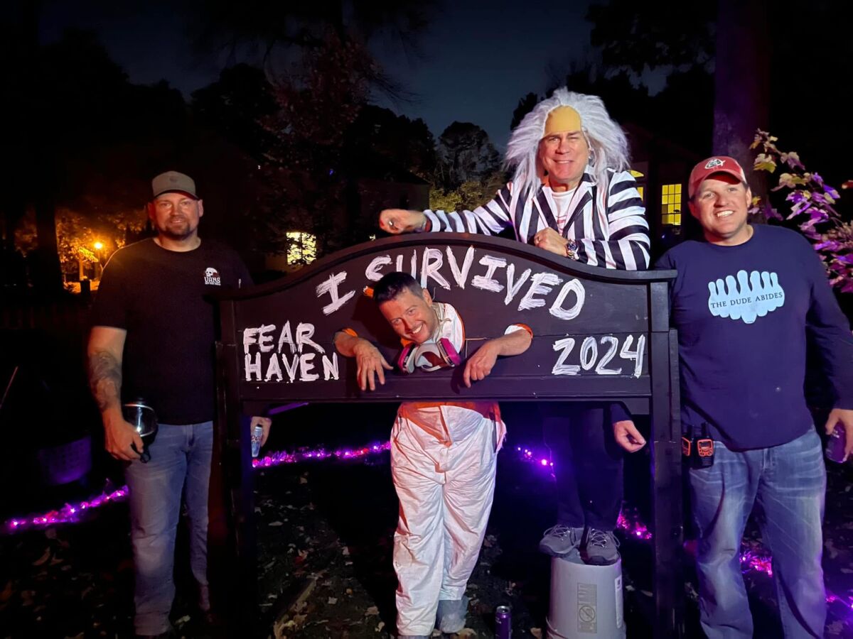 A man "trapped" in a sign that says "I survived Fear Haven 2024" 