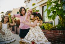 A woman and her two daughters dancing in the street