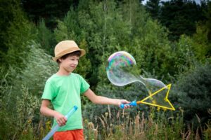 A child making a large bubble with a wand