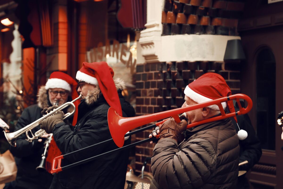 People in Santa hats playing the trombone