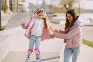 A mother helping her child roller skate