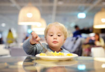 How To Eat Out With Toddlers, and Maybe Even Enjoy It toddler boy eating potatoes in indoors cafe