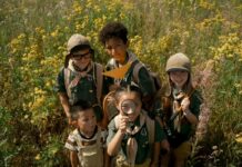 Children wearing scouting outfits in a field