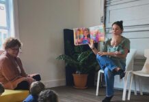 A woman reading a story to several children