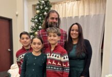 Family standing in front of a Christmas tree