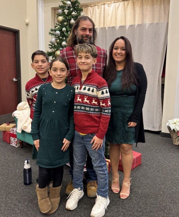 Family standing in front of a Christmas tree