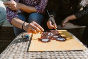 Two people painting a bear on a canvas