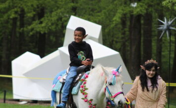 A child rides a "unicorn" at the Fairy & Gnome Home Festival