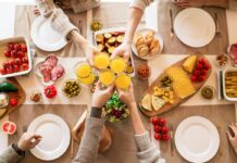 People toasting with orange juice over a brunch table