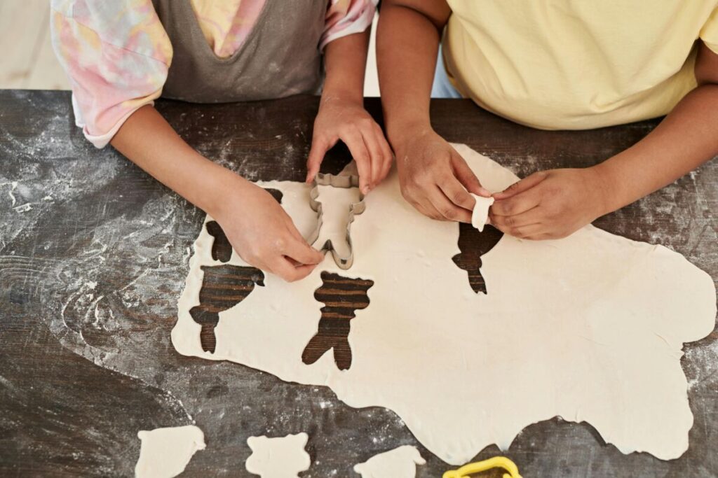 Kids cut out bunny shapes in dough as they bake in the kitchen