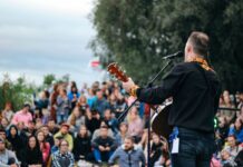 Man playing guitar at an outdoor concert