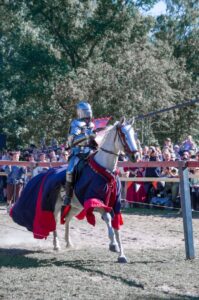 A jousting knight riding a white horse