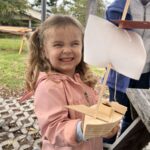 Girl holding a wooden boat
