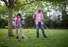 A girl and an older man raking leaves